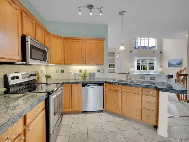 a kitchen with stainless steel appliances granite countertop a sink and dishwasher a stove top oven with wooden floor