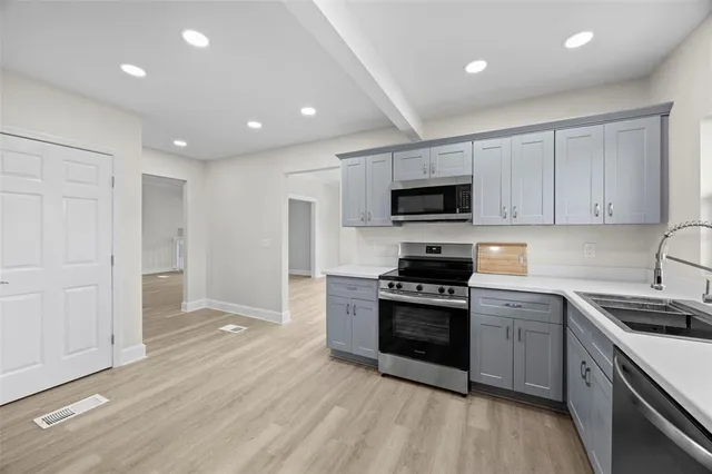 a kitchen with stainless steel appliances granite countertop a stove a sink and a microwave