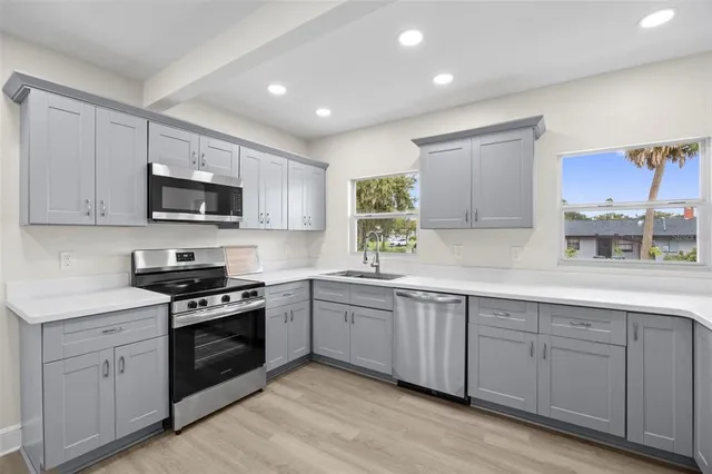 a kitchen with stainless steel appliances a refrigerator and a stove top oven