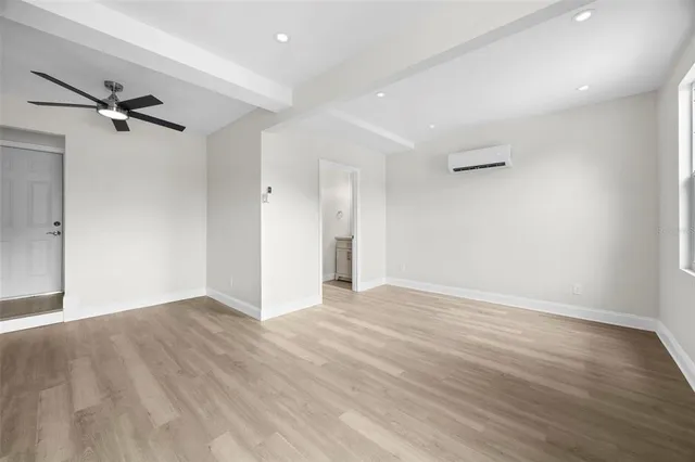 an empty room with wooden floor and closet area