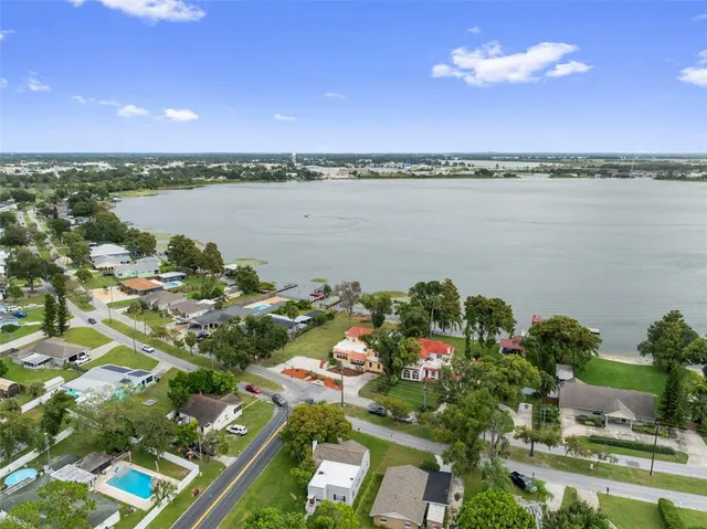 an aerial view of a city with lots of residential buildings ocean and mountain in the back