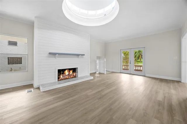 a view of a livingroom with wooden floor and a fireplace