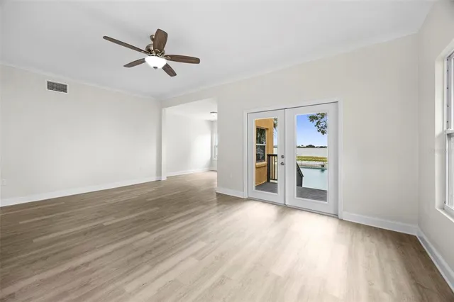 an empty room with wooden floor and window