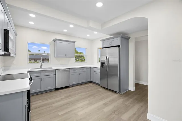 a kitchen with stainless steel appliances granite countertop a stove a sink and a refrigerator