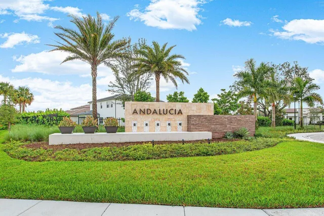 a white house with a big yard and palm trees