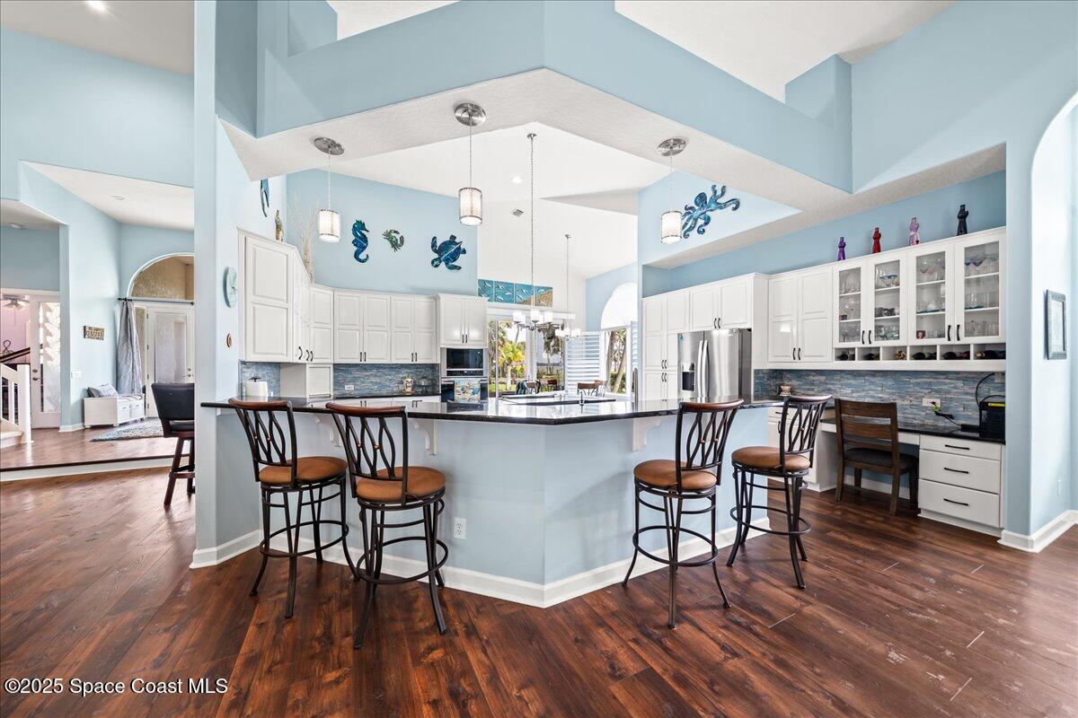 2089 Rockledge Drive Rockledge, FL 32955 - Photo 12 of 60 a kitchen with stainless steel appliances granite countertop wooden floor dining table and chairs