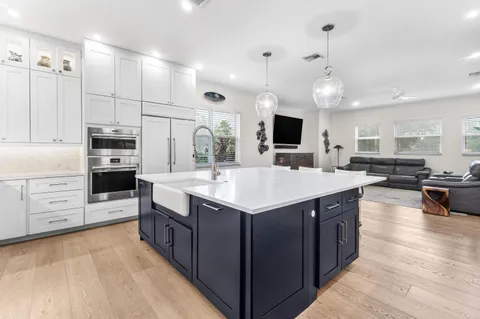 a large kitchen with kitchen island granite countertop a large center island and a wooden floor