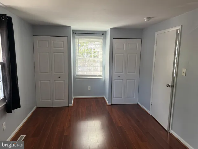 an empty room with wooden floor and a window