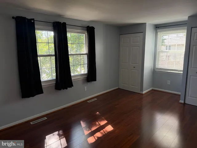 a living room with wooden floor and large window