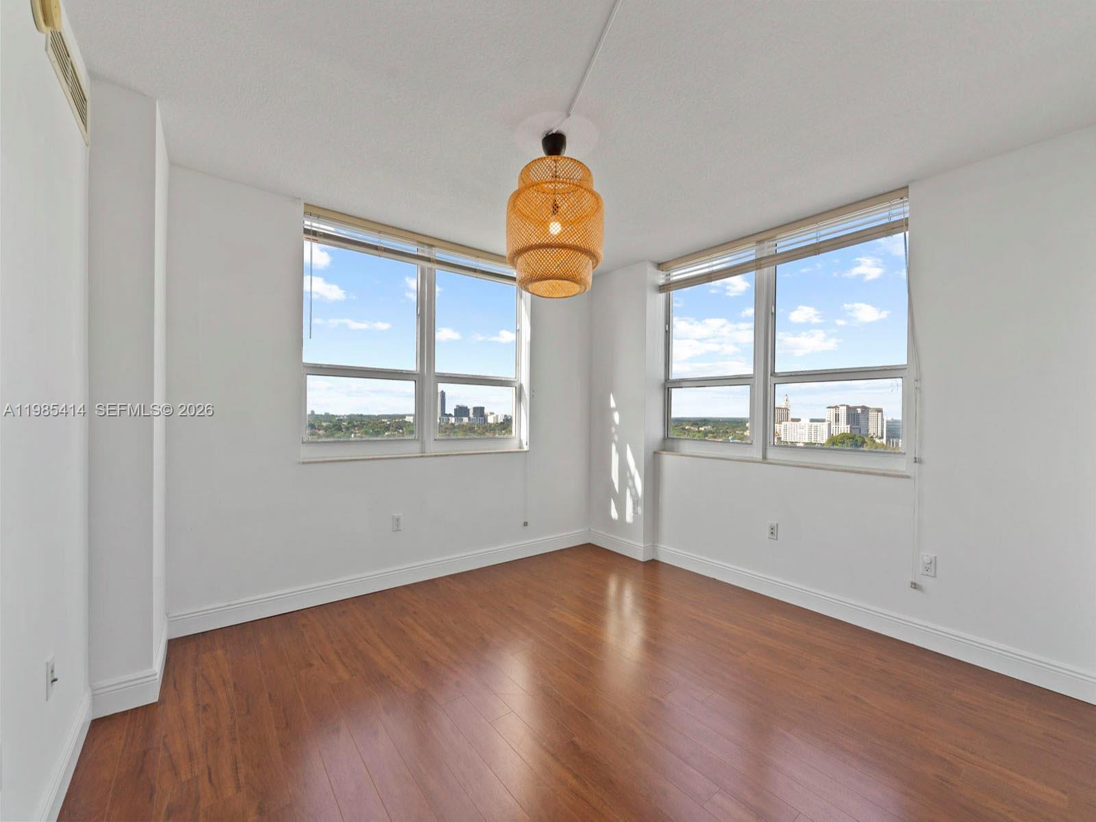 3232 Southwest 22nd Terrace, Unit 1609 Miami, FL 33145 - Photo 15 of 37 wooden floor in an empty room with a window
