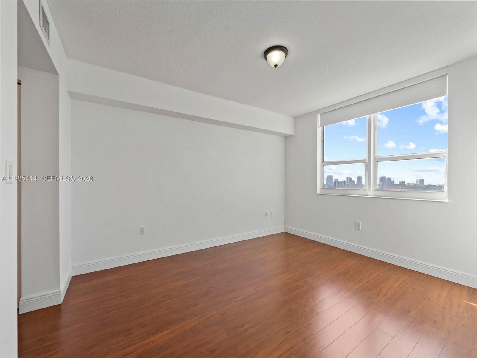 3232 Southwest 22nd Terrace, Unit 1609 Miami, FL 33145 - Photo 17 of 37 an empty room with wooden floor and windows