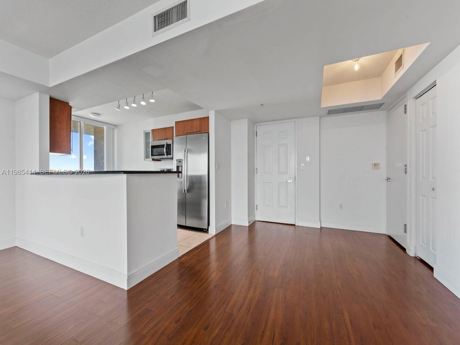 3232 Southwest 22nd Terrace, Unit 1609 Miami, FL 33145 - Photo 4 of 37 a view of a kitchen with wooden floor and electronic appliances