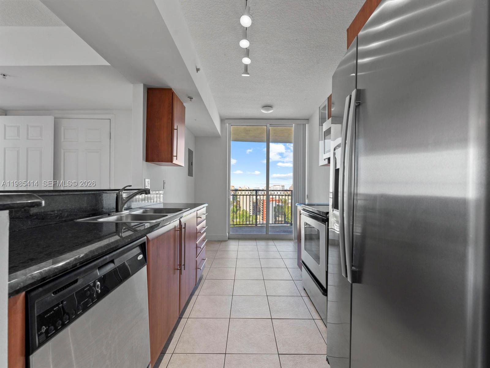3232 Southwest 22nd Terrace, Unit 1609 Miami, FL 33145 - Photo 5 of 37 a kitchen with stainless steel appliances granite countertop a refrigerator and a sink