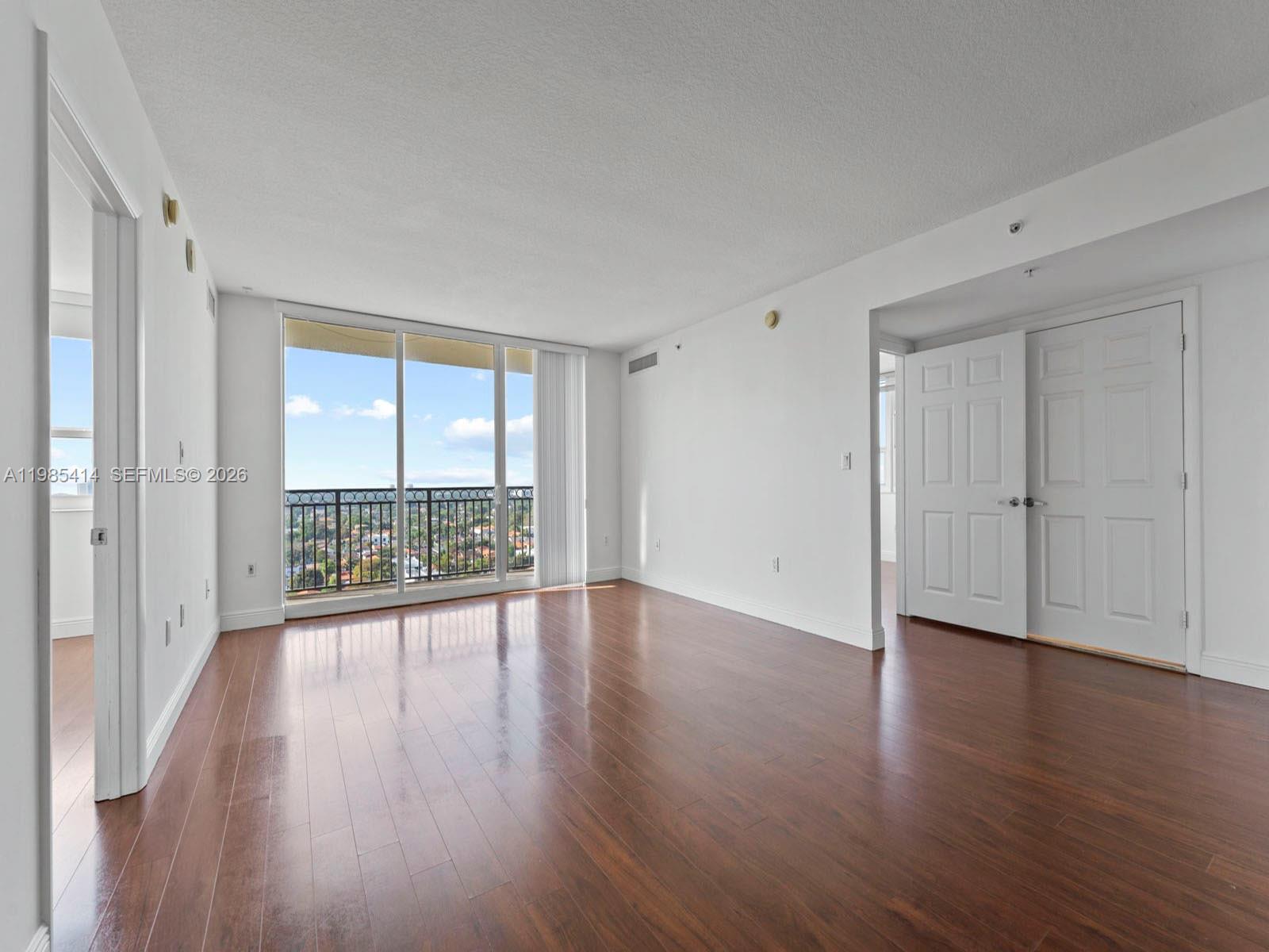 3232 Southwest 22nd Terrace, Unit 1609 Miami, FL 33145 - Photo 8 of 37 a view of an empty room with wooden floor and a window