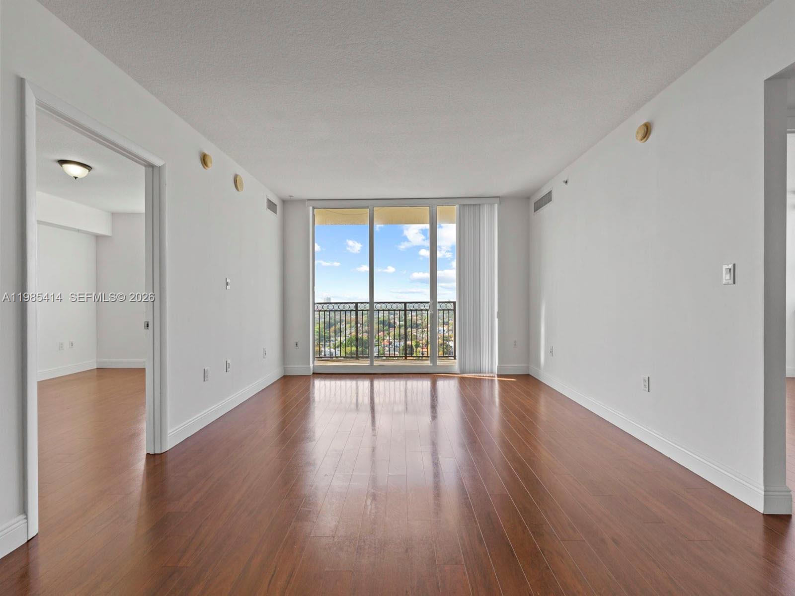 3232 Southwest 22nd Terrace, Unit 1609 Miami, FL 33145 - Photo 9 of 37 a view of an empty room with wooden floor and a window