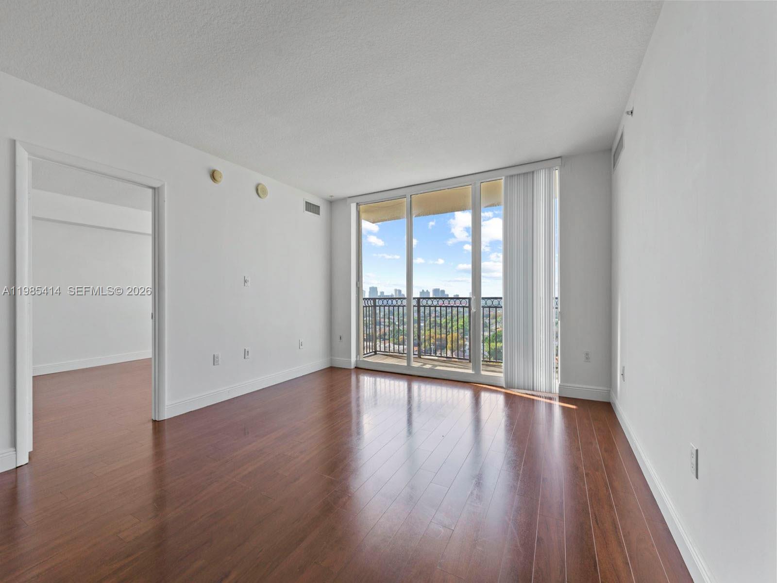3232 Southwest 22nd Terrace, Unit 1609 Miami, FL 33145 - Photo 10 of 37 a view of an empty room with wooden floor and a window
