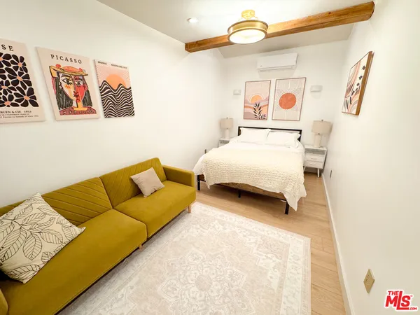 a bedroom with a bed couch and painting on the wall