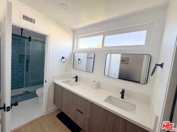 a bathroom with a sink a toilet and mirror