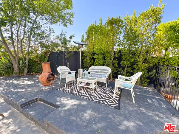 a view of a patio with a table and chairs and potted plants