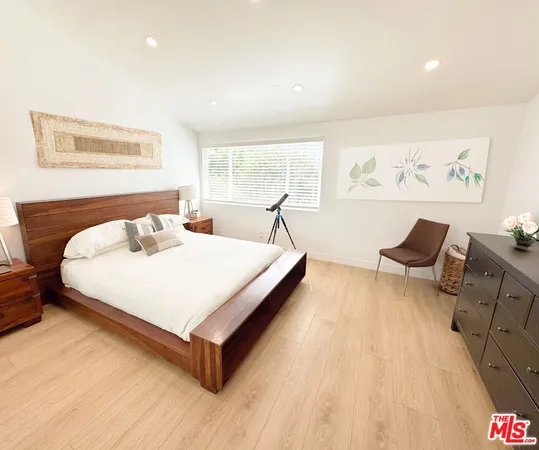a bed sitting in a spacious bedroom next to a window