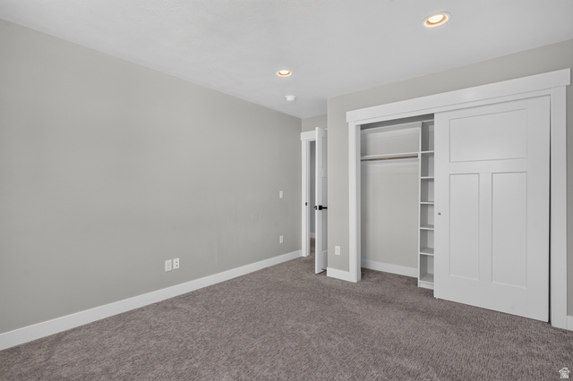 36 West Syracuse Road Vineyard, UT 84059 - Photo 39 of 56 Recessed lighting illuminates a neutral gray room featuring soft gray carpeting, white baseboards, and a white interior door