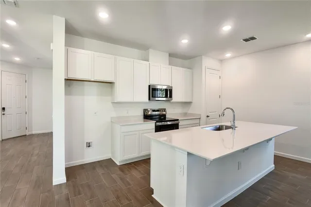 a kitchen with a sink a microwave a stove and refrigerator