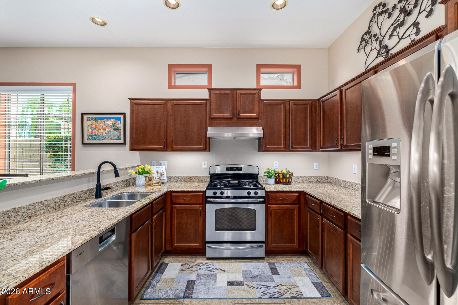 6202 East McKellips Road, Unit 297 Mesa, AZ 85215 - Photo 12 of 57 a kitchen with stainless steel appliances granite countertop a stove a sink dishwasher a refrigerator and a microwave oven with wooden floor
