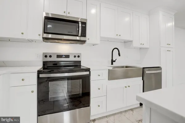 a kitchen with stainless steel appliances granite countertop grey cabinets a stove a sink and dishwasher