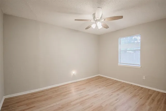 a view of a room with wooden floor and fan