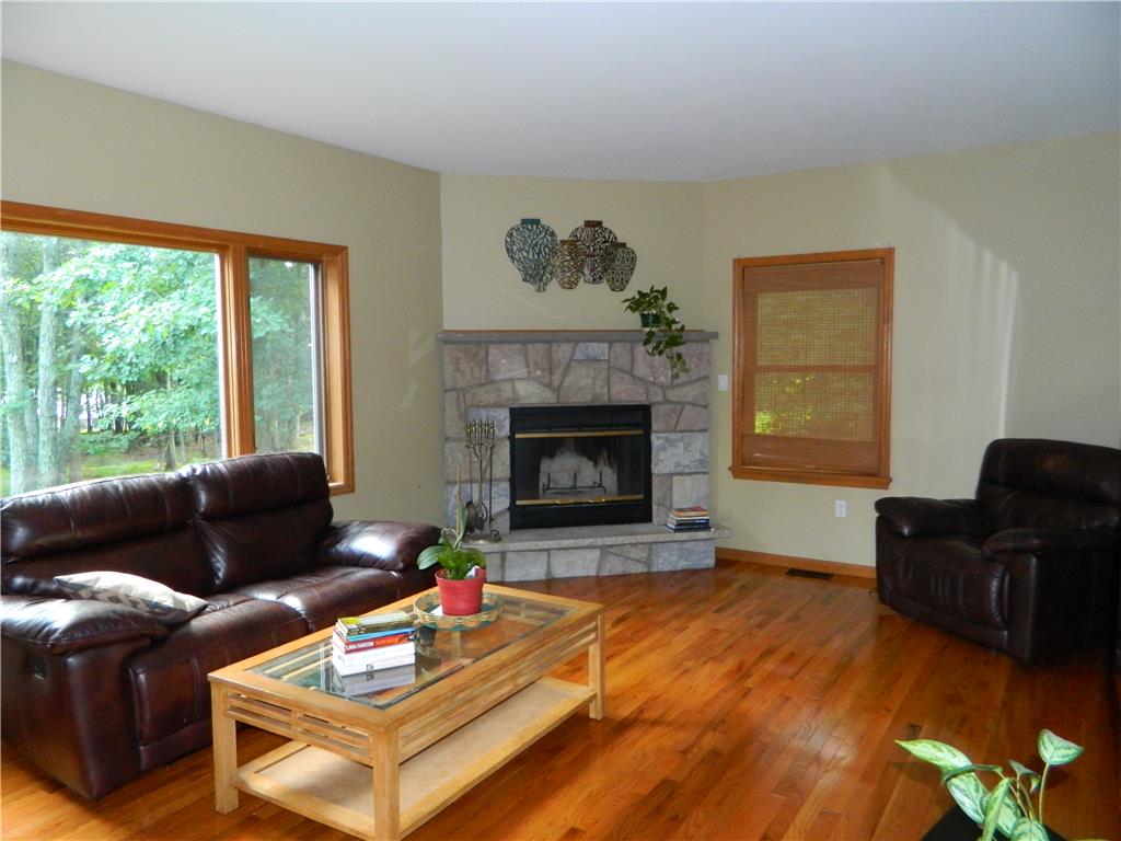 328 Pin Oak Road Stroudsburg, PA 18360 - Photo 16 of 42 Hardwood floors and a stone fireplace create a warm and inviting ambiance in this ample living space.