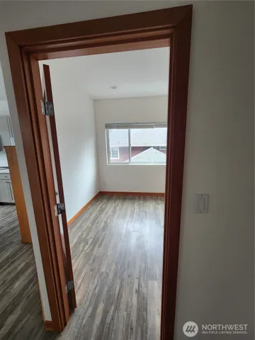 a view of a hallway with wooden floor and a window