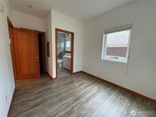 an empty room with wooden floor and closet