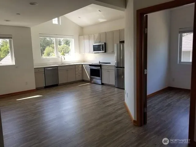 a large kitchen with hardwood floor and a window