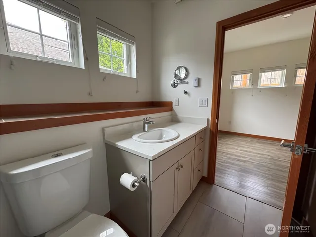 a bathroom with a sink toilet and window
