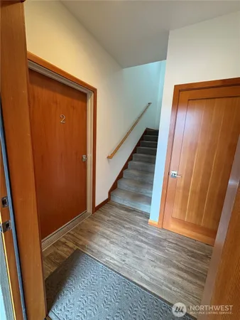 a view of a hallway with wooden floor and stairs