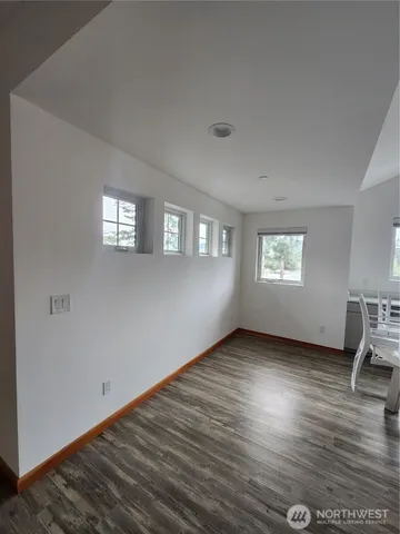 a view of a room with wooden floor and windows