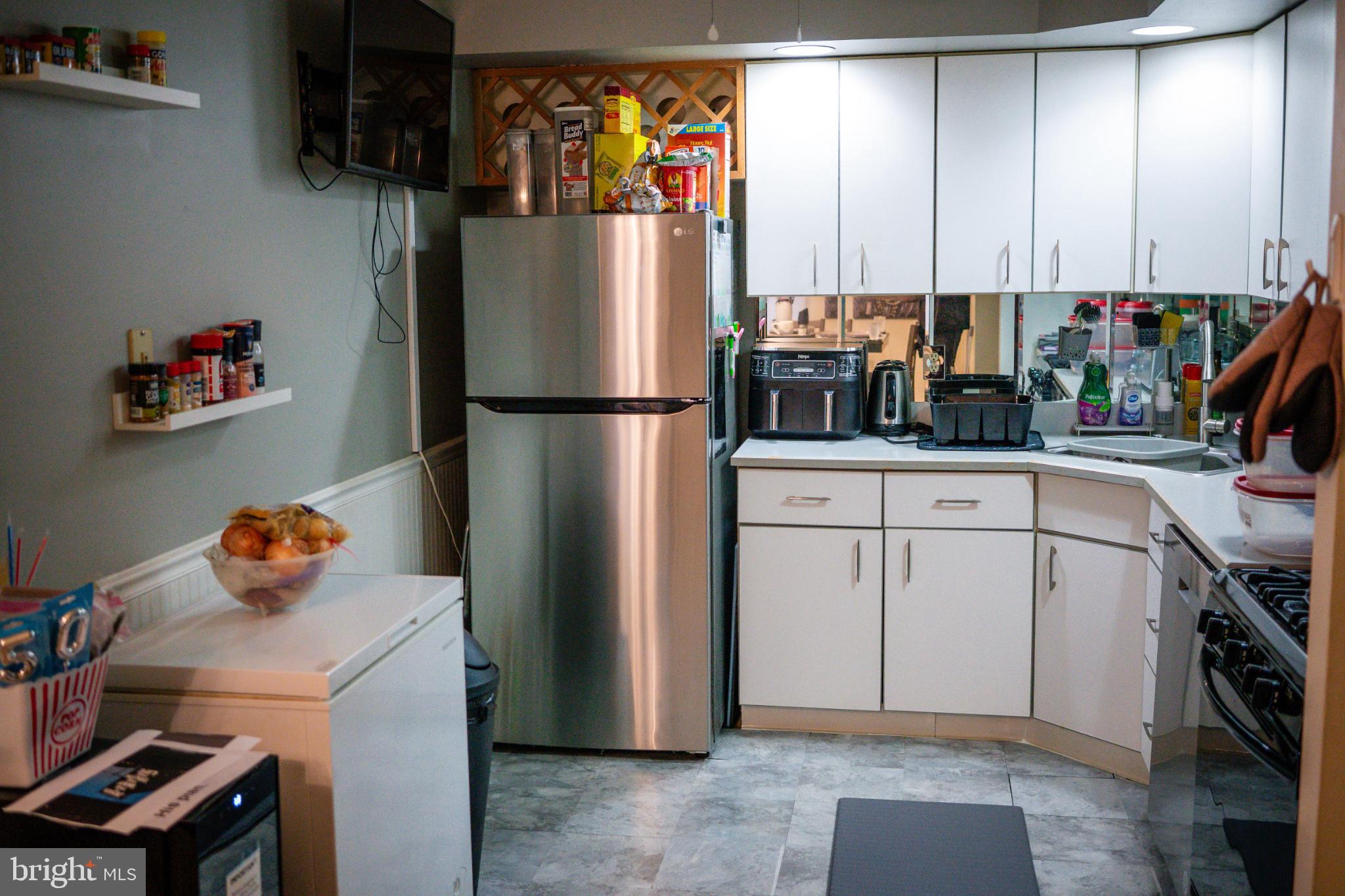2089 Welsh Road, Unit F1 Philadelphia, PA 19115 - Photo 23 of 27 a kitchen with stainless steel appliances a refrigerator sink and cabinets