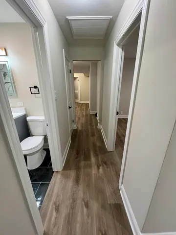 a view of a hallway with wooden floor and furniture