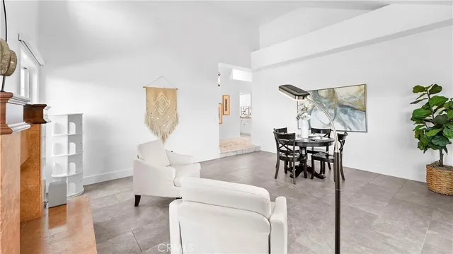 a open kitchen with stainless steel appliances granite countertop a stove top oven a sink dishwasher a dining table and chairs with wooden floor