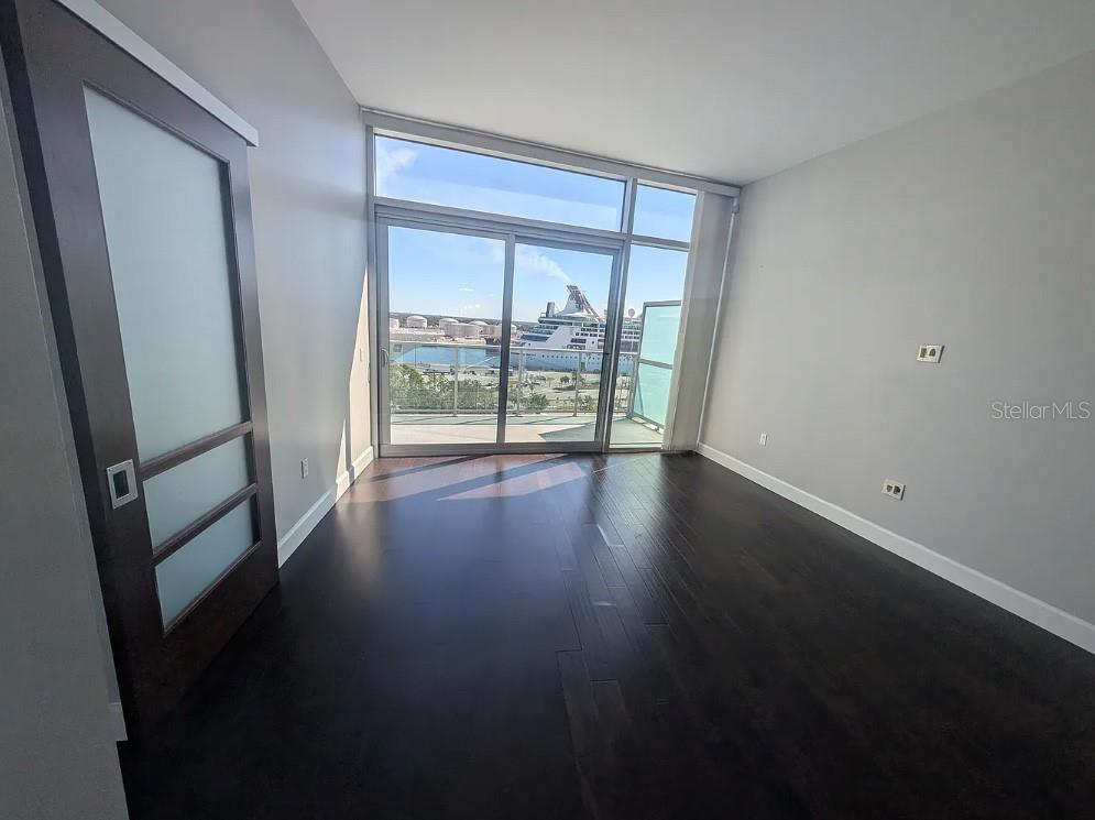 912 Channelside Drive, Unit 2803 Tampa, FL 33602 - Photo 29 of 34 an empty room with wooden floor and sliding door