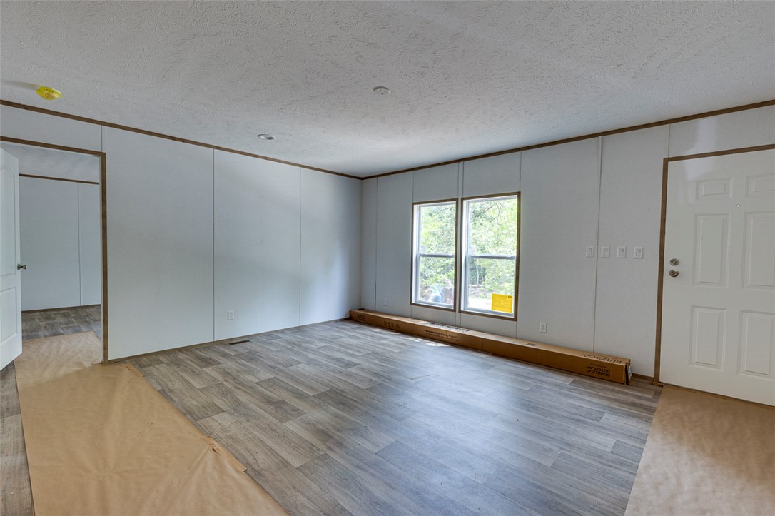 474 Bryant Road Pelzer, SC 29669 - Photo 11 of 42 Well-lit living area with durable laminate flooring and large windows inviting ample daylight.