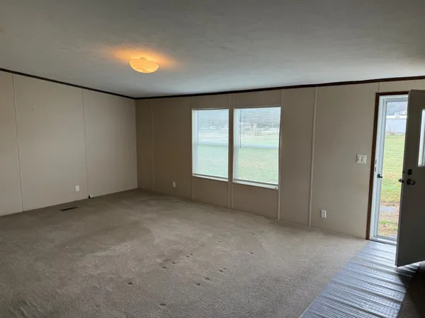 an empty room with windows and closet