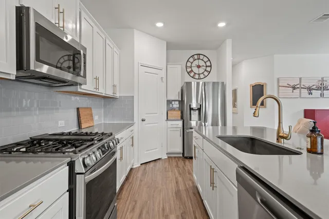 a kitchen with stainless steel appliances granite countertop a stove and a sink