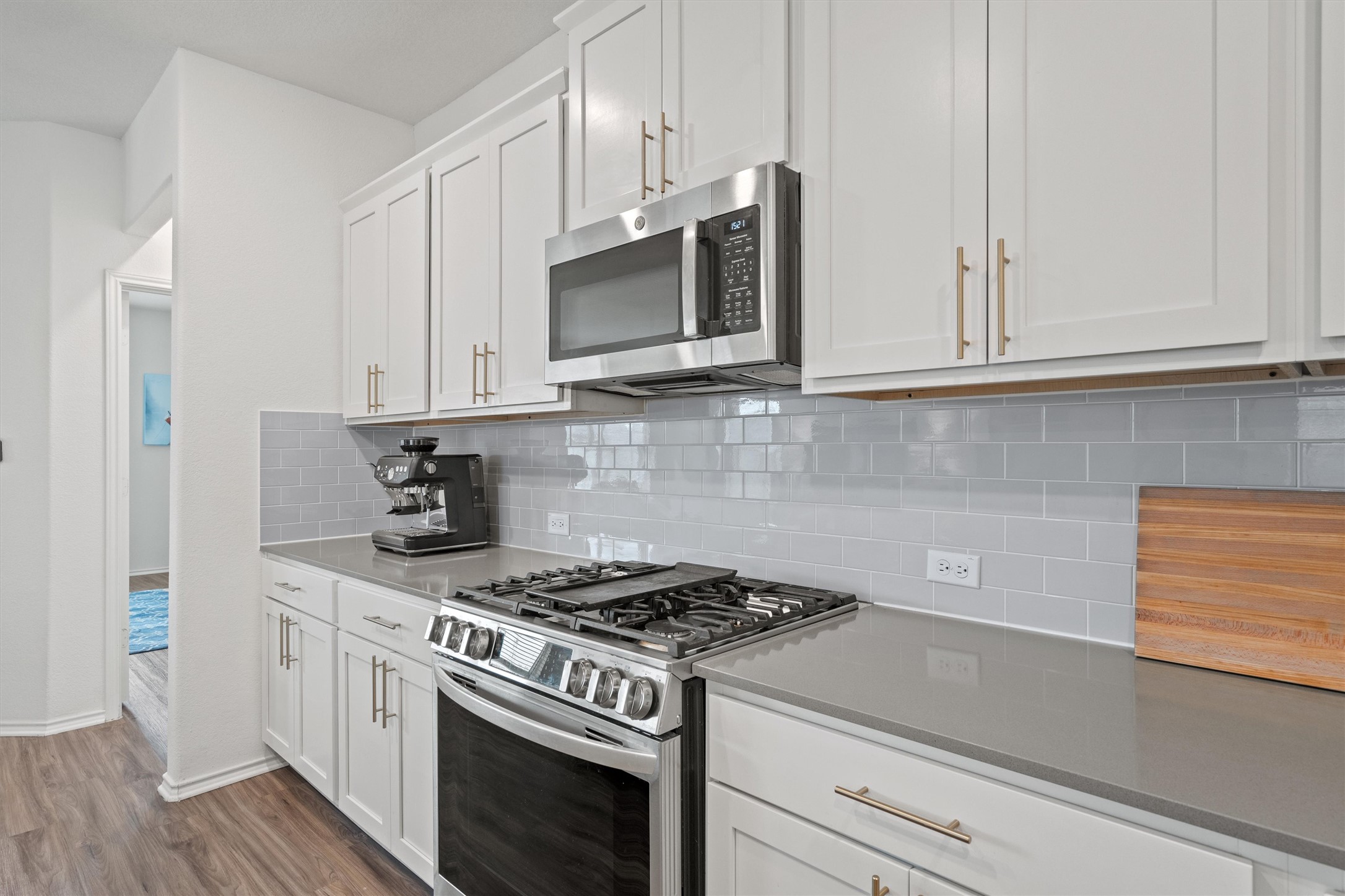 424 Wolf Springs Road Georgetown, TX 78628 - Photo 13 of 35 a kitchen with stainless steel appliances granite countertop white cabinets and a stove a oven with wooden floor