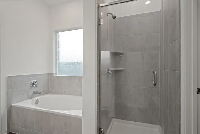 a white bath tub sitting next to a white sink and vanity