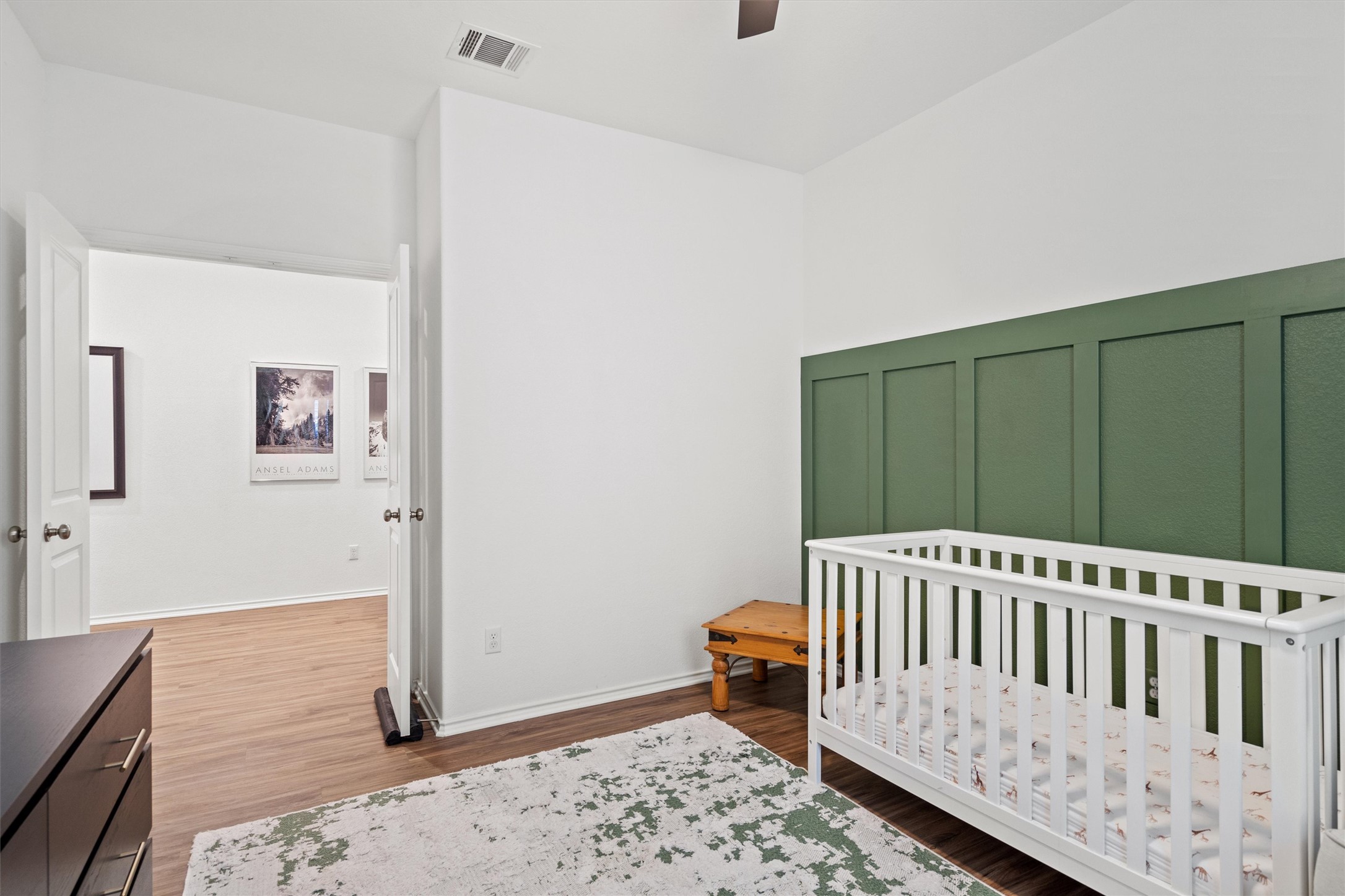 424 Wolf Springs Road Georgetown, TX 78628 - Photo 25 of 35 a bedroom with a baby crib and wooden floor