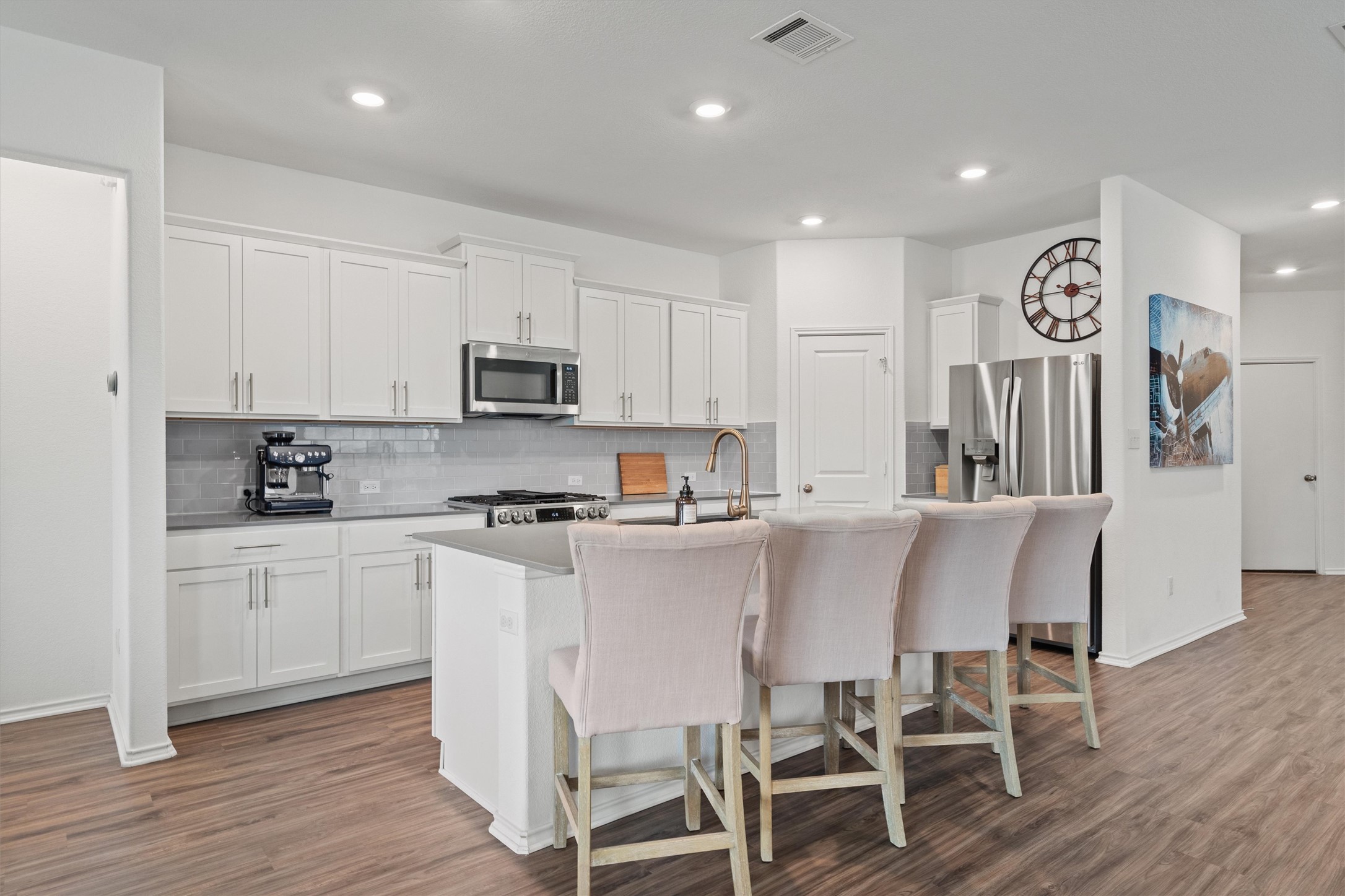 424 Wolf Springs Road Georgetown, TX 78628 - Photo 5 of 37 a kitchen with stainless steel appliances granite countertop a white cabinets and wooden floor