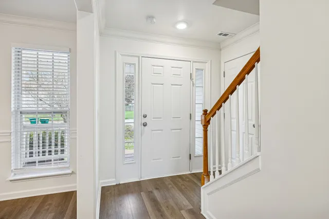 a view of a hallway with a white walls and wooden floor