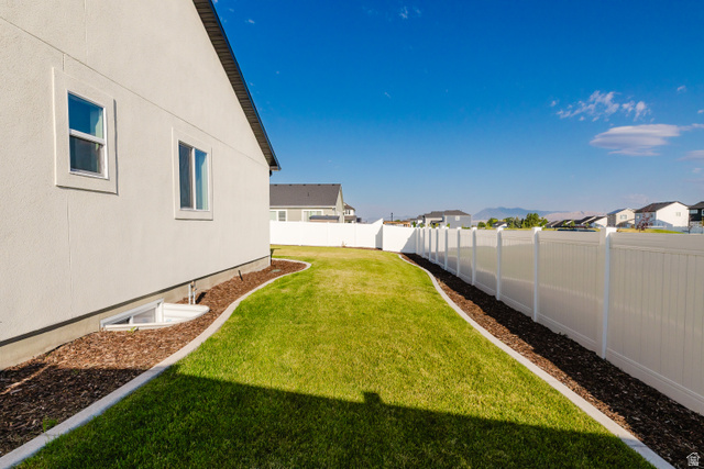 433 North 600 West Smithfield, UT 84335 - Photo 7 of 40 Expansive backyard featuring a manicured lawn, a full vinyl privacy fence, and a decorative mulch border