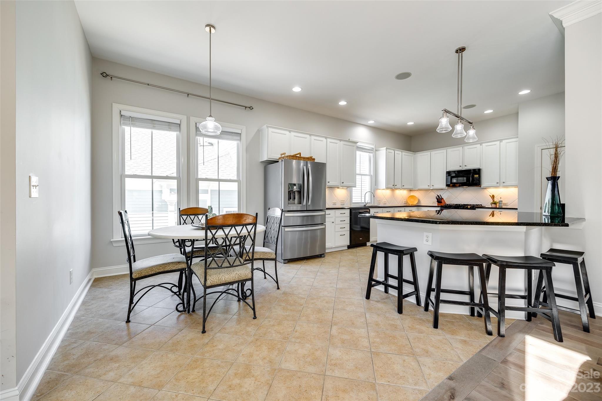 109 Mills Lane Fort Mill, SC 29708 - Photo 15 of 48 a kitchen with stainless steel appliances kitchen island granite countertop a table chairs and a refrigerator